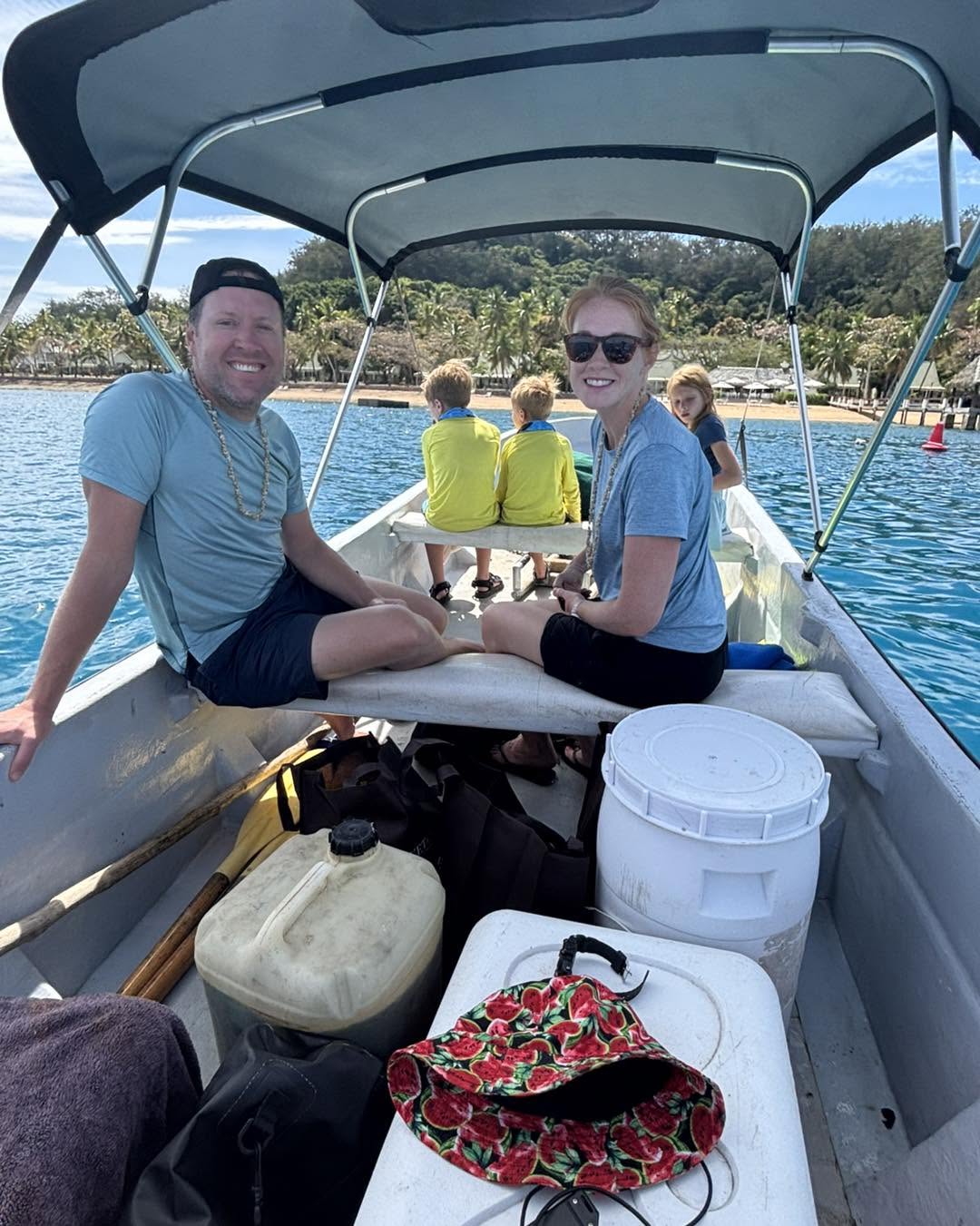 Family relaxing on the boat with a resort beach in the background
